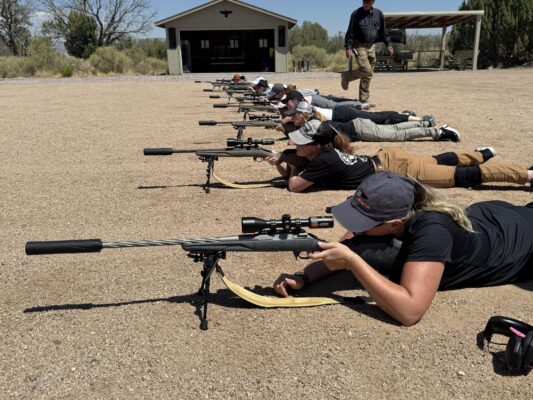 Line of women shooting rifles in prone position.